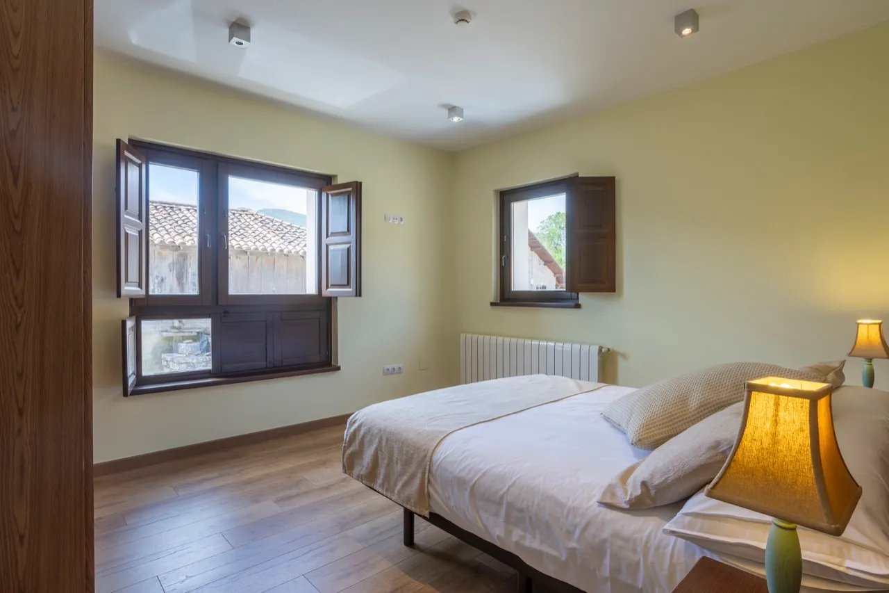 Dormitorio del apartamento con ventanas y vistas al pueblo